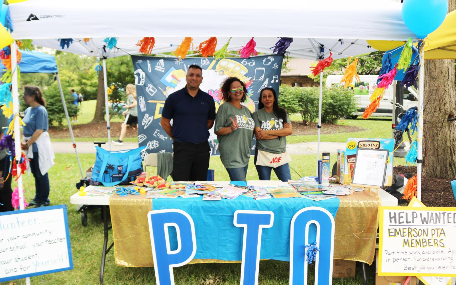 An image of Emerson PTA members posing at their table set-up at the Back to School Picnic