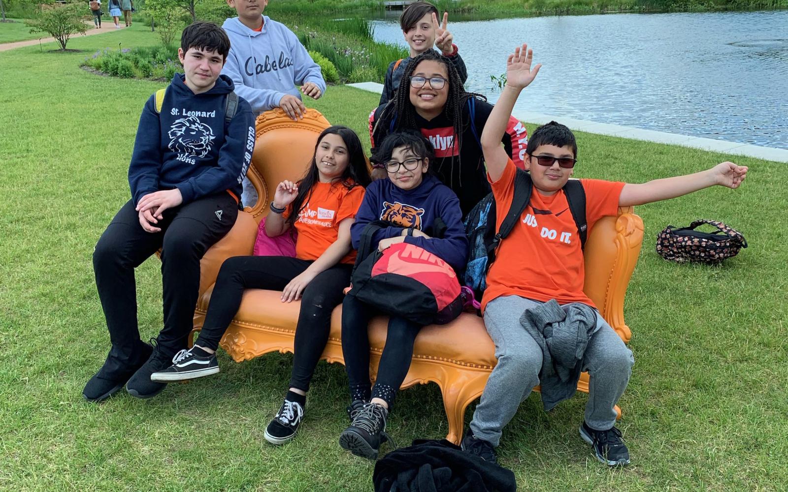 photo of teenagers seven teenagers sitting on a bench by a pond from the Berwyn Park Districts teen camp program