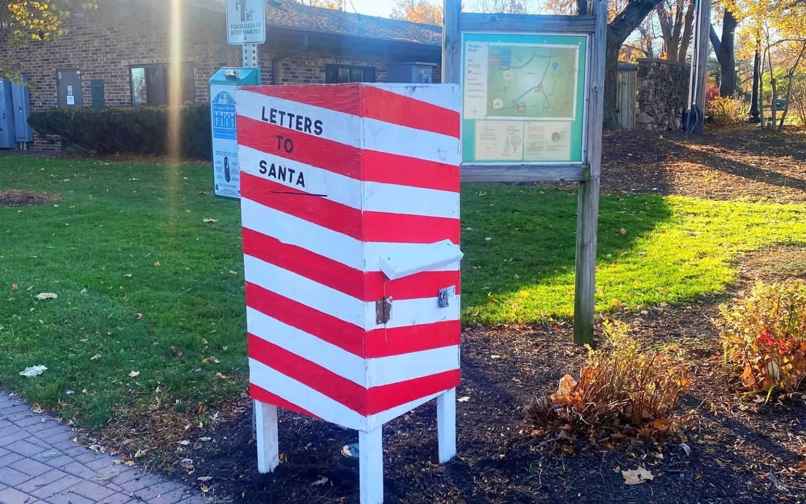 A large boxed placed near a pathway with candy cane striping and the words letters to santa on the side