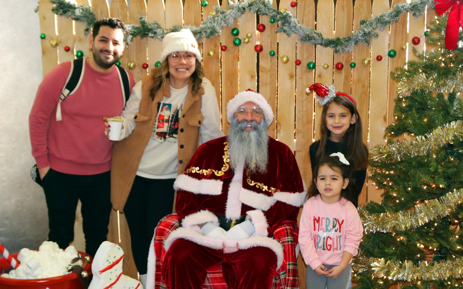 A Family with Santa next to the Christmas Tree